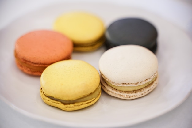 Gâteau pastel coloré macaron ou macaron sur plaque blanche posée sur une table