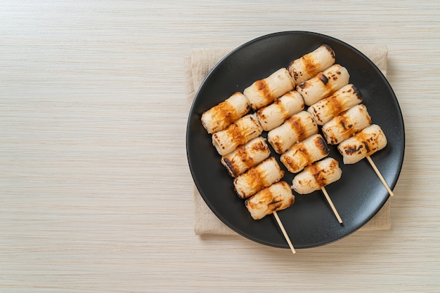 gâteau de pâte de poisson grillé en forme de tube ou brochette de calmar en tube sur assiette