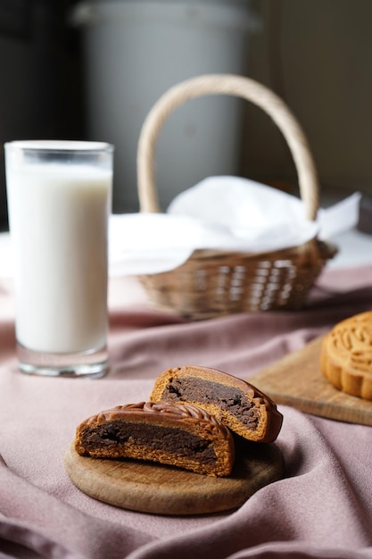 Gâteau de pâtisserie traditionnel Mooncake coupé en deux montrant une garniture sucrée avec un verre de lait.