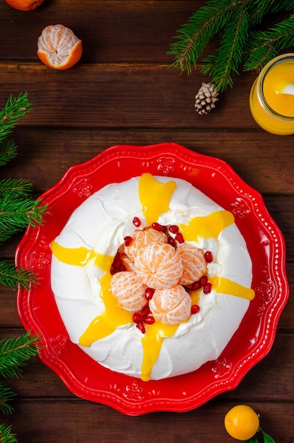 Gâteau Pavlova de Noël avec crème fouettée mandarines et grenade Copy space