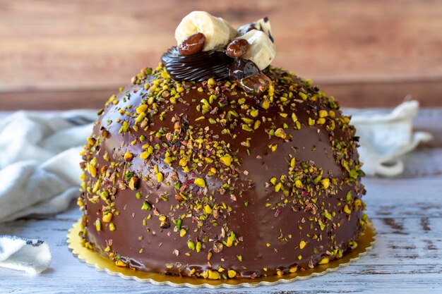 Gâteau à la pistache et au chocolat sur fond de bois rustique Gâteau d'anniversaire et de célébration Produits de boulangerie en gros plan