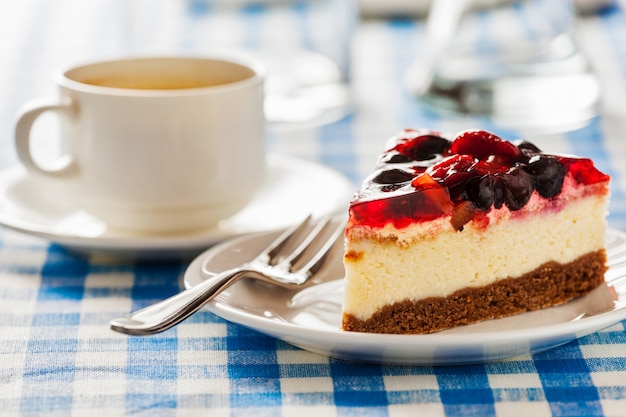 Gâteau sur plaque avec fourchette et tasse à café