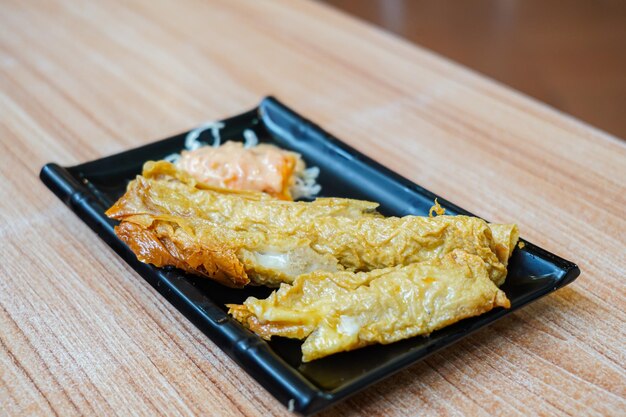 gâteau de poisson grillé ( otak otak ) Gâteaux de poisson frits sur une assiette, servis avec salade de légumes