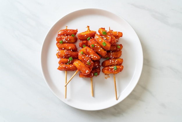 gâteau de riz coréen frit (Tteokbokki) embroché avec sauce épicée - style cuisine coréenne