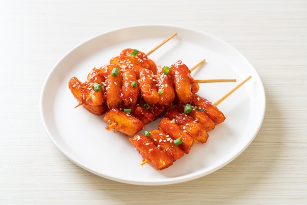 gâteau de riz coréen frit (Tteokbokki) embroché avec sauce épicée - style cuisine coréenne