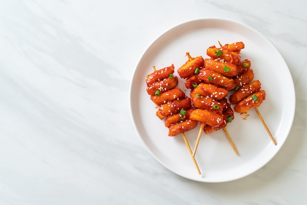 gâteau de riz coréen frit (Tteokbokki) embroché avec sauce épicée - style cuisine coréenne