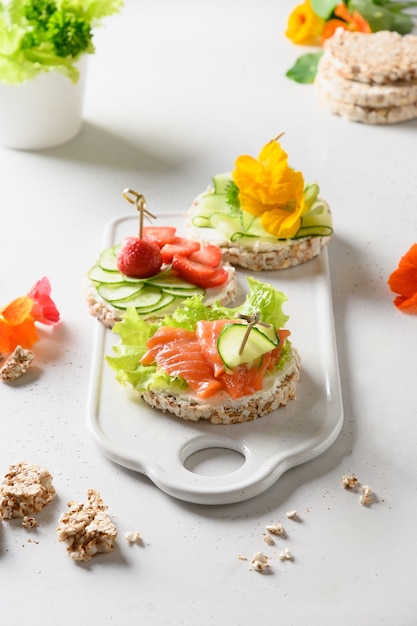 Gâteau de riz croustillant avec poisson rouge et légumes sur fond blanc.