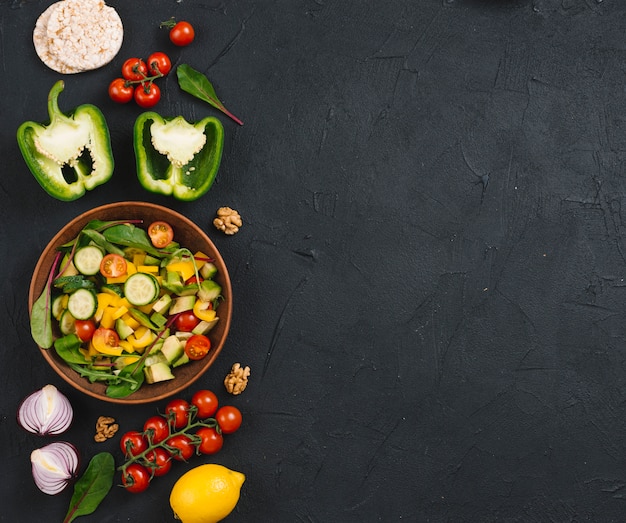 Gâteau de riz soufflé; des légumes; salade et noix sur le comptoir de cuisine noir