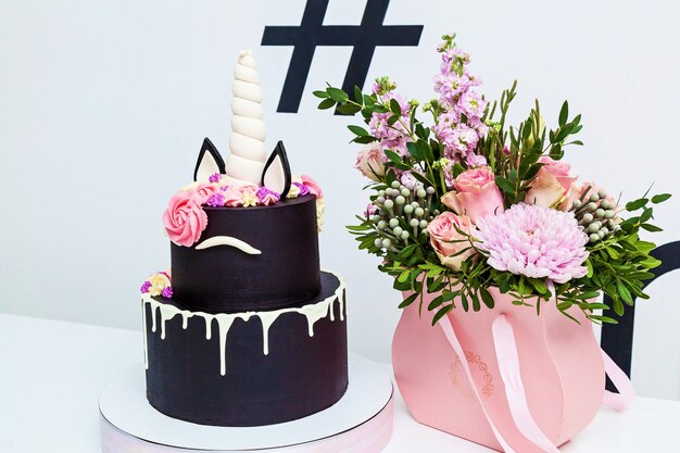 Gâteau rond à deux niveaux en forme de licorne sur fond blanc