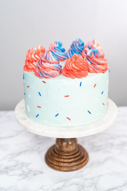 Gâteau rond à la vanille rouge, blanc et bleu avec glaçage à la crème au beurre pour la célébration du 4 juillet.