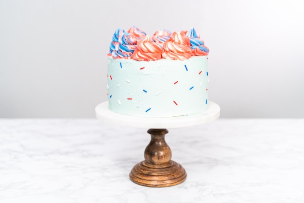 Gâteau rond à la vanille rouge, blanc et bleu avec glaçage à la crème au beurre pour la célébration du 4 juillet.