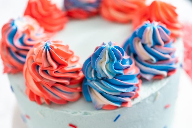 Gâteau rond à la vanille rouge, blanc et bleu avec glaçage à la crème au beurre pour la célébration du 4 juillet.