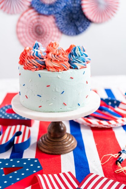 Gâteau rond à la vanille rouge, blanc et bleu avec glaçage à la crème au beurre pour la célébration du 4 juillet.