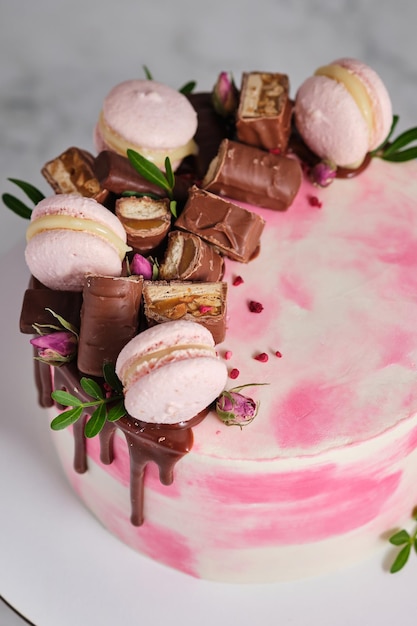 Gâteau rose et blanc pour une fille Dessert décoré de chocolat et de pâtes