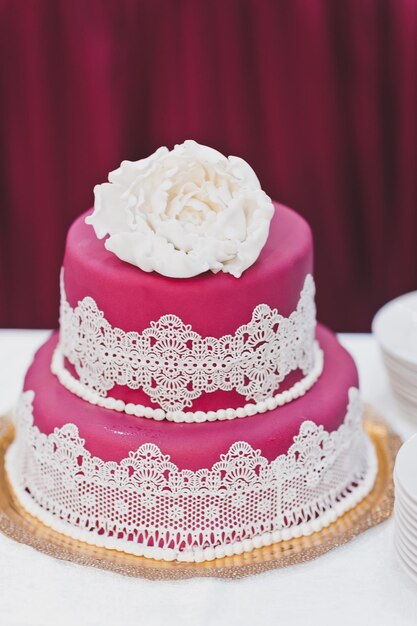 Photo gâteau rose avec décorations blanches 7989