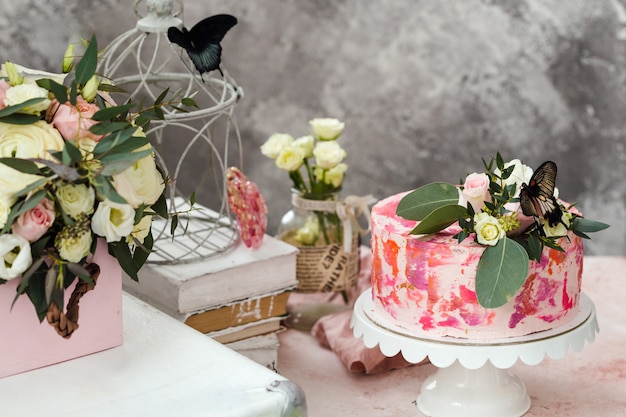 Photo gâteau rose décoré de fleurs et de vrais papillons rose ambiance romantique