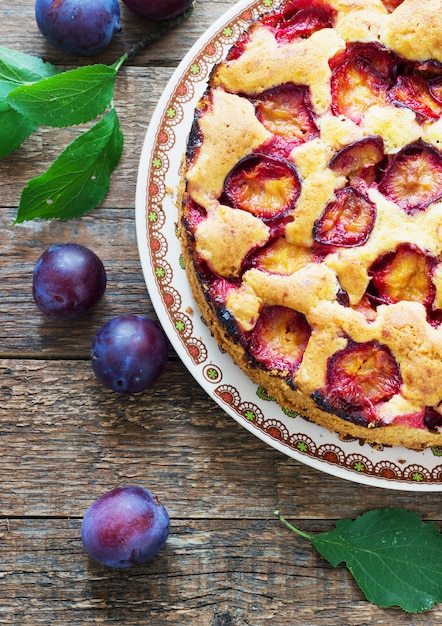 Gâteau rustique aux prunes sur une table en bois sombre