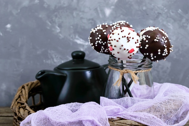 Photo le gâteau saute. bonbons ronds sur un bâton dans un glaçage au chocolat.