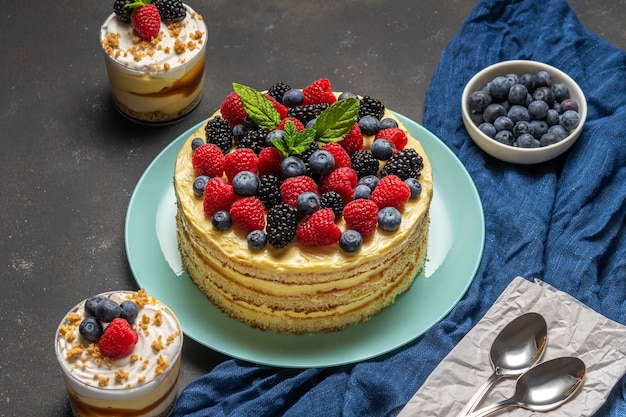 Gâteau savoureux avec des baies fraîches et des desserts sucrés sur fond noir.