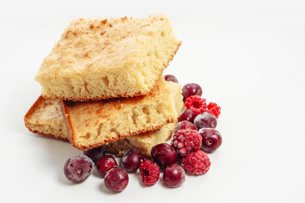 Gâteau de semoule aux framboises et cerises isolé sur surface blanche