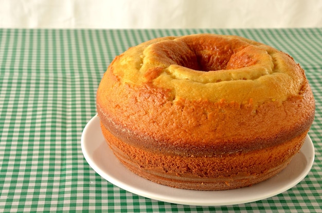 gâteau simple sur la table avec nappe à carreaux vert