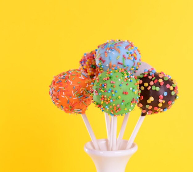 Gâteau sucré apparaît dans un vase sur fond jaune