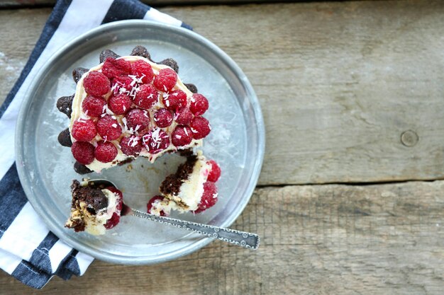 Photo gâteau sucré aux framboises sur fond de table en bois