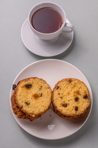 Gâteau sucré et thé sur fond gris.