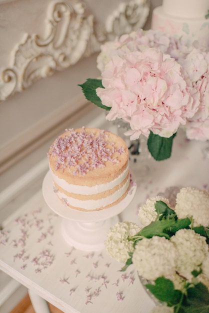 Un gâteau sur une table avec un bouquet de fleurs