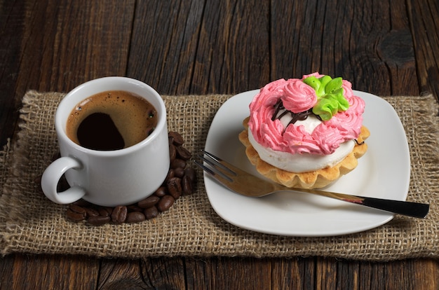 Gâteau et tasse de café chaud sur une table en bois sombre