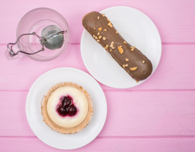 Gâteau et thé dans un verre sur un fond en bois rose