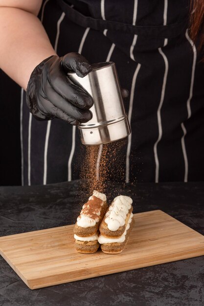 Photo un gâteau de tiramisu dessert sur un plateau sur un fond sombre