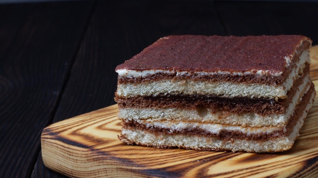 gâteau tiramisu sur une planche à découper sur une table en bois sombre