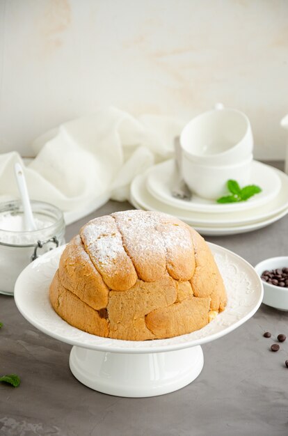 Gâteau traditionnel italien Zuccotto sur une assiette blanche décorée de sucre en poudre et de baies sur le dessus.