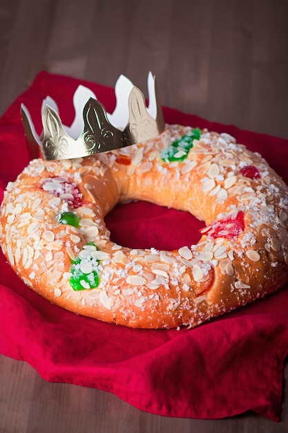 Gâteau traditionnel de l'Épiphanie Roscon de Reyes avec couronne sur table en bois libre