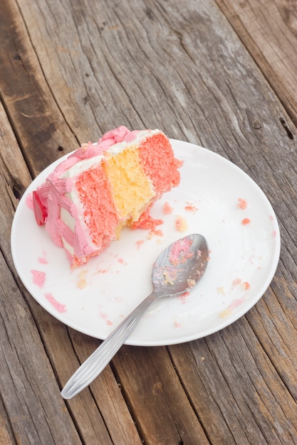 Gâteau vanille restes dans une assiette blanche avec une cuillère.