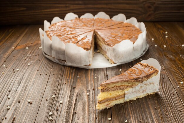 Gâteau végétalien au chocolat noir avec des bonbons et des noix sur fond de bois