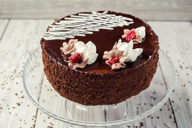 Gâteau végétalien au chocolat noir avec des cerises sur fond de bois