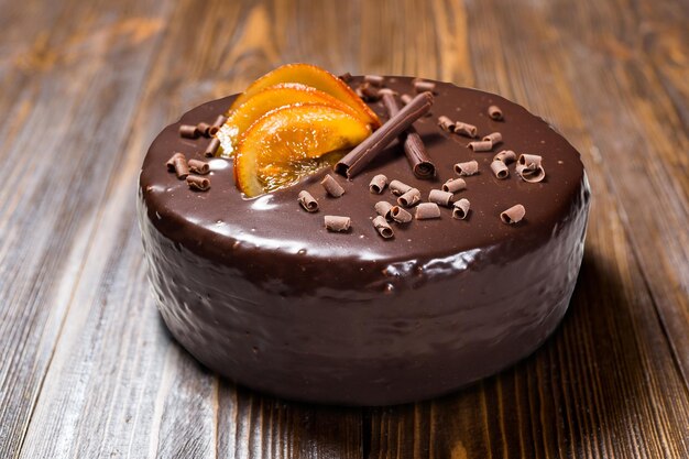 Gâteau végétalien au chocolat noir avec des oranges confites sur fond de bois