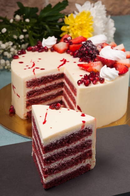 Gâteau de velours rouge doux avec des fraises et de la crème fouettée