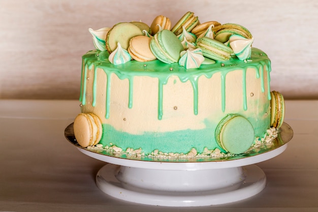 Gâteau vert crémeux sucré avec des macarons sur le dessus