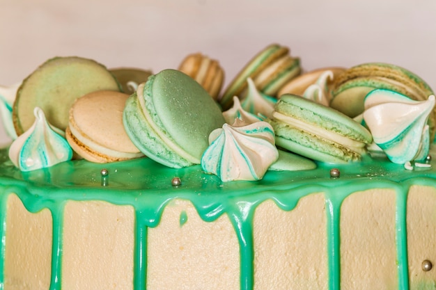 Gâteau vert crémeux sucré avec des macarons sur le dessus