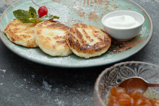 Gâteaux au fromage avec de la confiture dans l'assiette. Crêpes à la confiture sur plaque.