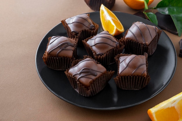 Gâteaux de bonbons au chocolat avec garniture orange sur fond marron. Dessert au chocolat.