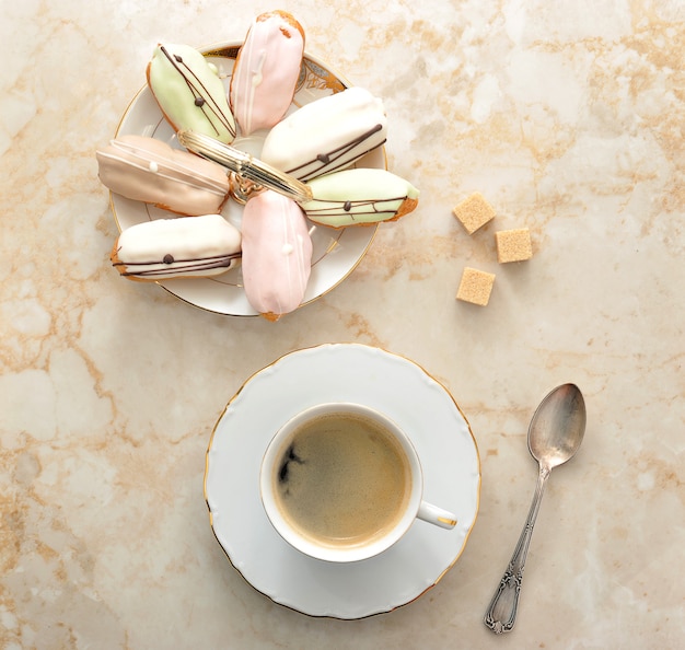 Gâteaux dans l'assiette et café dans une tasse avec une cuillère et du sucre