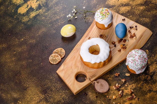 Gâteaux de fête avec glaçage blanc, noix et raisins secs avec des œufs de Pâques sur la table de fête. Préparatifs de Pâques