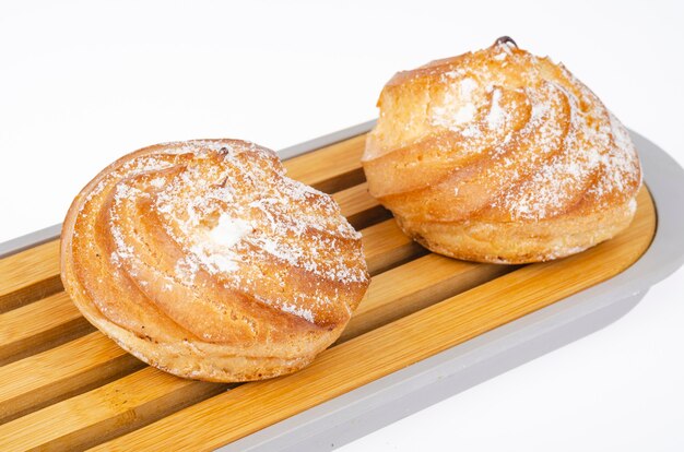 Gâteaux frais faits maison avec de la crème et du sucre en poudre. Studio photo.