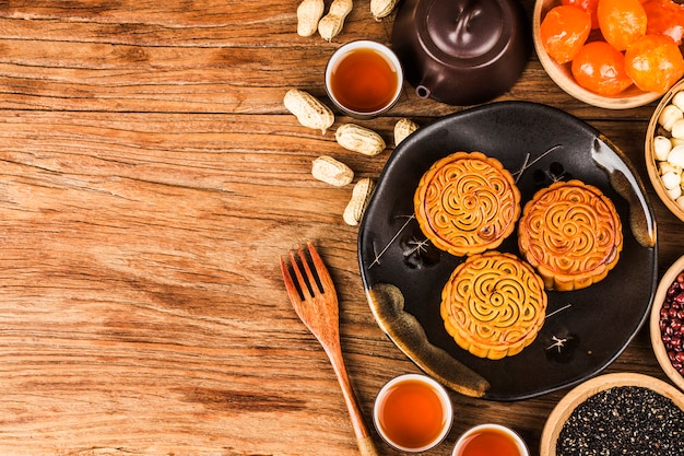 Gâteaux de lune traditionnels sur le réglage de la table avec une tasse de thé.