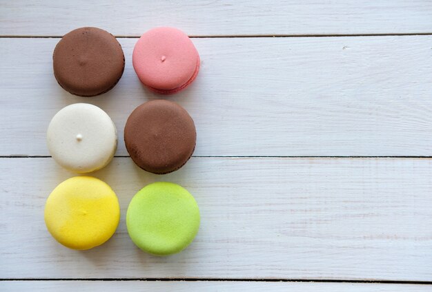 Gâteaux macarons colorés sur la vue de dessus de table en bois blanc