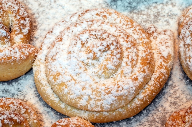 Photo des gâteaux maison sucrés saupoudrés de sucre de vanille, de petits biscuits du four sur une feuille de cuisson.